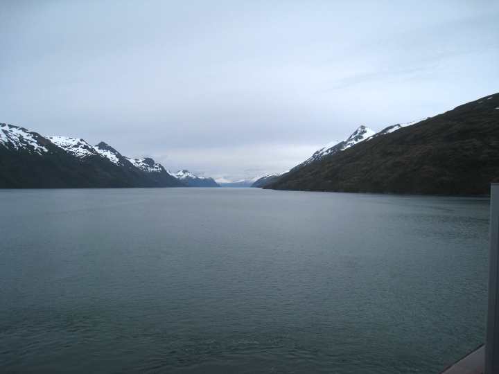 An almost straight channel of water with steep mountain peaks on either side