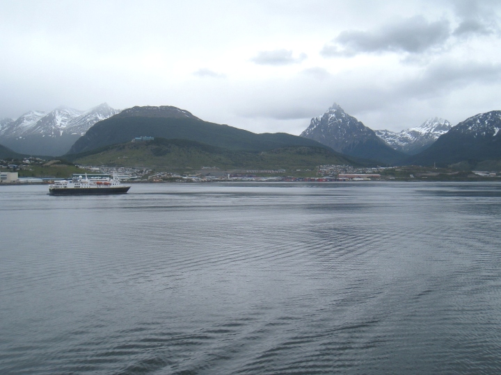 shipboard view of a harbour, with snow-capped peaks in background