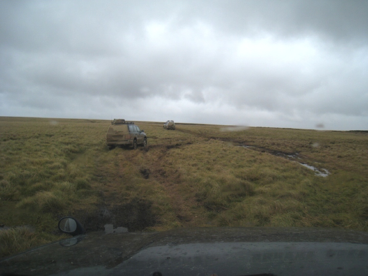 vehicles negotiating a soggy, peat-y cross-country route