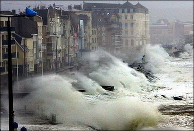dramatic photo of waves hitting a French town
