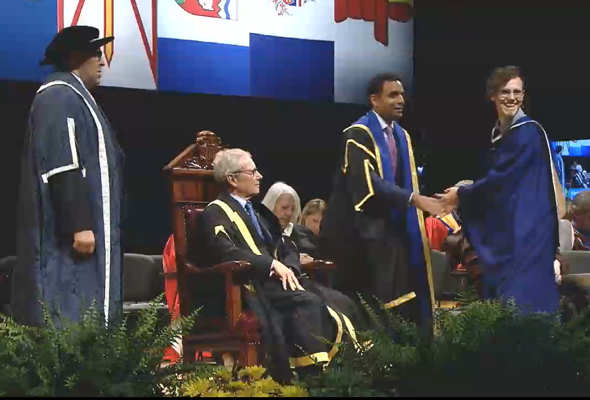 Markus Harwood-Jones is seen being congratulated by university officials as he receives his degree