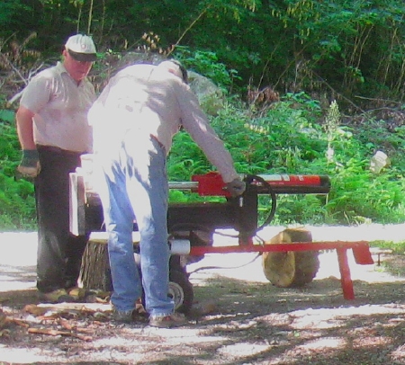 two men operating a wood-splitter